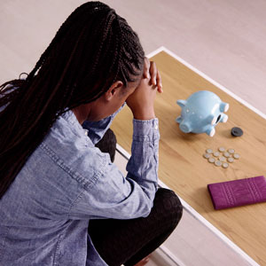 image of lady praying and empty piggy bank